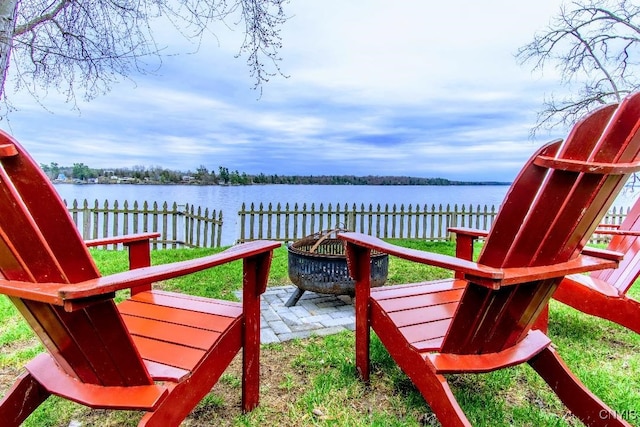 exterior space featuring fence, a water view, and a fire pit