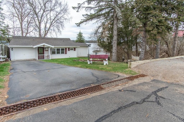 ranch-style home with a garage, a front yard, and aphalt driveway