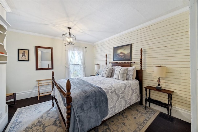bedroom featuring dark wood-style floors, baseboards, an inviting chandelier, crown molding, and wooden walls