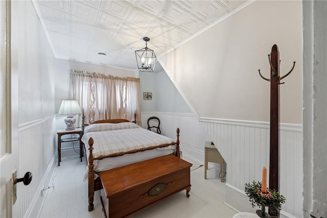 bedroom with an ornate ceiling, a wainscoted wall, and visible vents