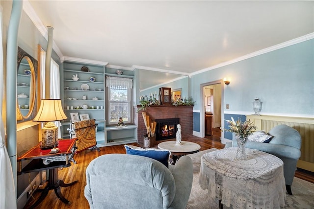 living area featuring wood finished floors, a fireplace, and crown molding
