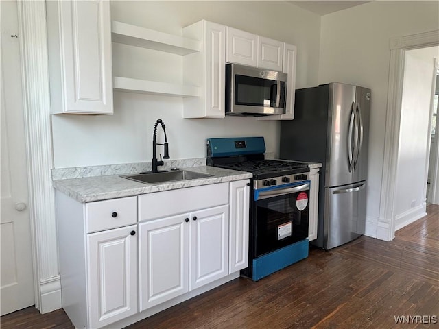 kitchen with open shelves, white cabinets, appliances with stainless steel finishes, and a sink