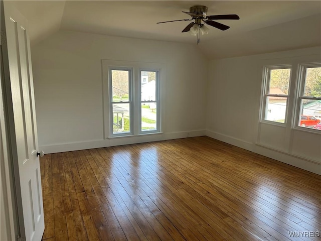 empty room with hardwood / wood-style flooring, lofted ceiling, a ceiling fan, and baseboards