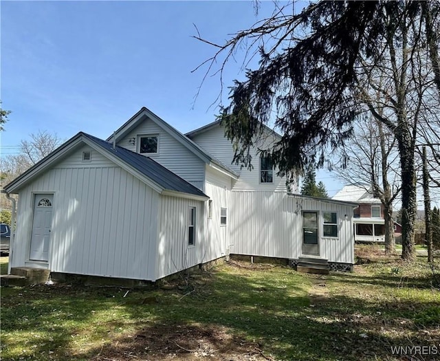view of side of property with a lawn and entry steps