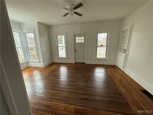 entryway featuring dark wood-type flooring, baseboards, and ceiling fan