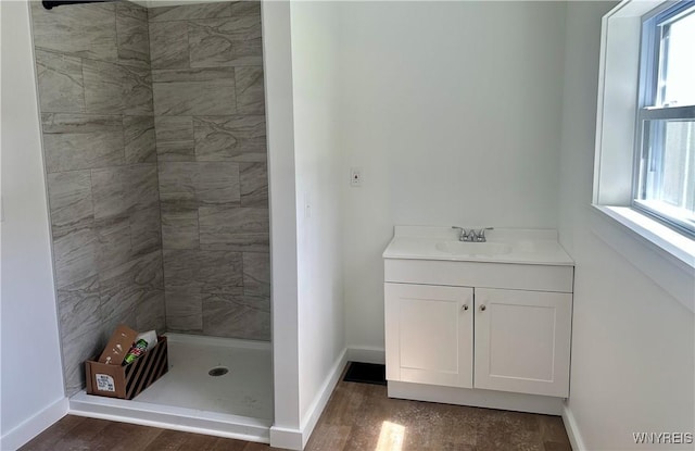bathroom featuring baseboards, vanity, wood finished floors, and a shower stall