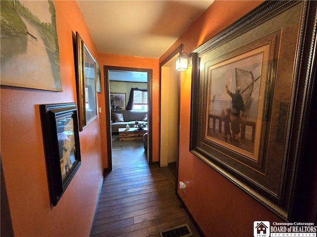 hall with baseboards, dark wood-type flooring, and visible vents