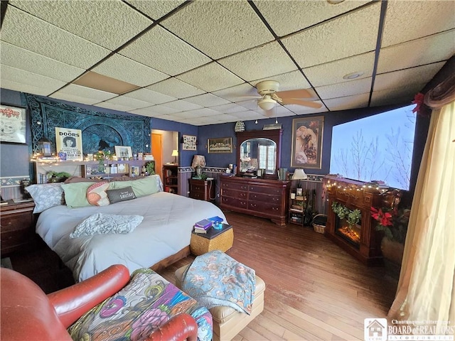 bedroom featuring wood finished floors and a drop ceiling