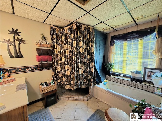 bathroom with a tub, tile patterned floors, and a paneled ceiling