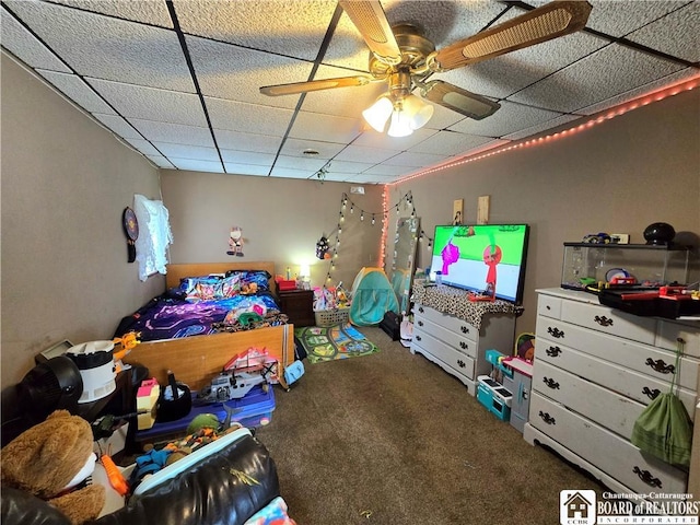 bedroom with a ceiling fan, carpet floors, and a drop ceiling