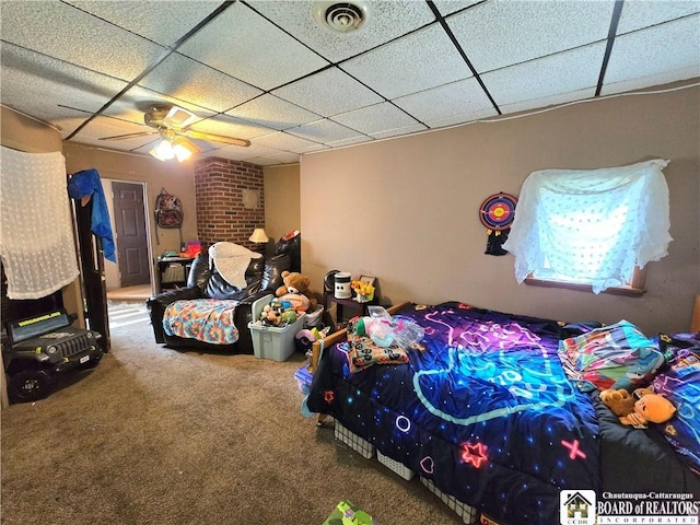 carpeted bedroom with a paneled ceiling, visible vents, and a ceiling fan