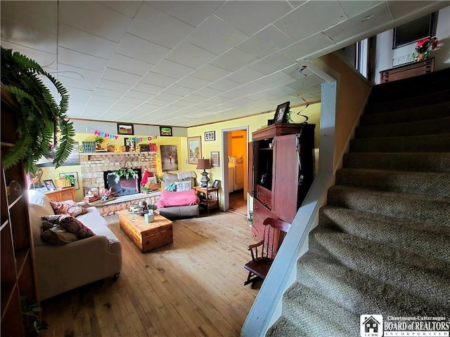 living room with hardwood / wood-style flooring, a fireplace, and stairs