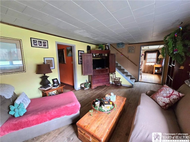 living area featuring wood finished floors and stairs