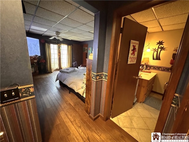 bedroom featuring wood-type flooring and a drop ceiling