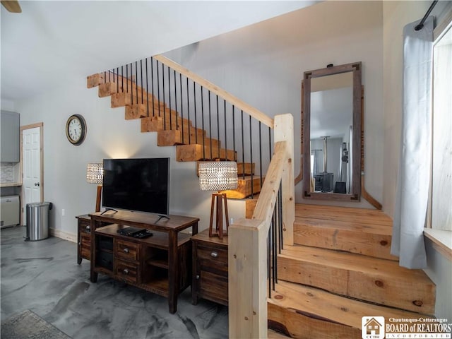 stairs featuring baseboards and finished concrete floors