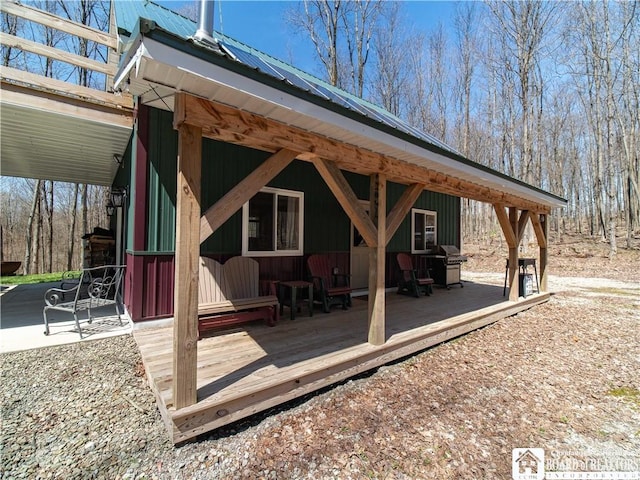 exterior space with a wooden deck and a grill