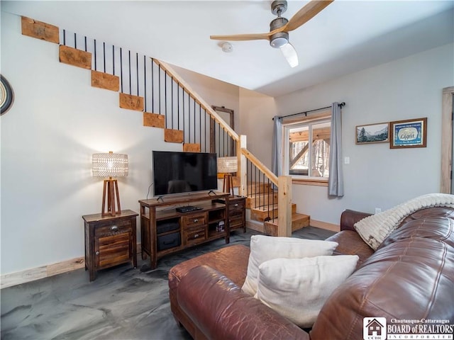 living room featuring baseboards, stairs, and ceiling fan
