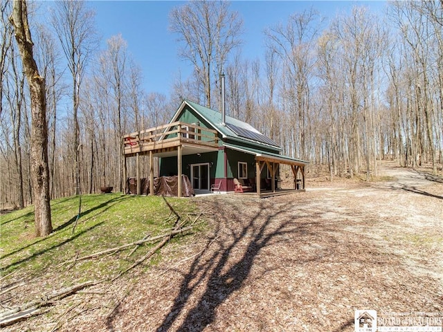 view of front of house featuring a wooden deck and metal roof
