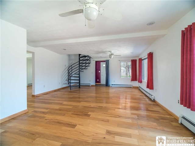 unfurnished living room featuring a baseboard heating unit, stairs, and ceiling fan