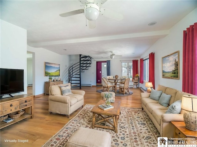 living area with a baseboard heating unit, light wood finished floors, a ceiling fan, and stairs