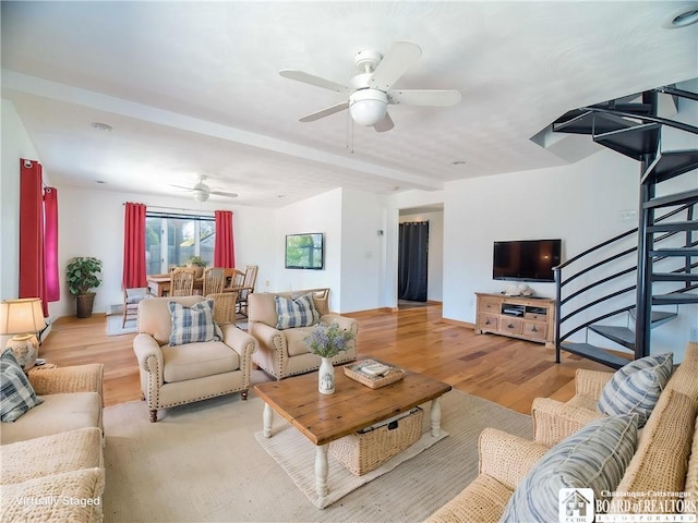 living room with wood finished floors, stairs, and ceiling fan
