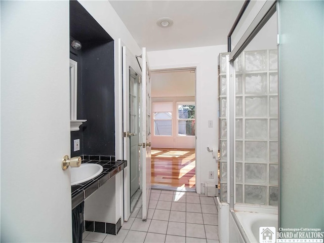 bathroom featuring a sink, tile patterned floors, and a bathing tub