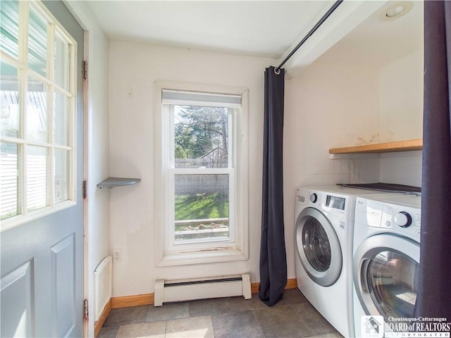 washroom with a baseboard heating unit, baseboards, washer and clothes dryer, and laundry area