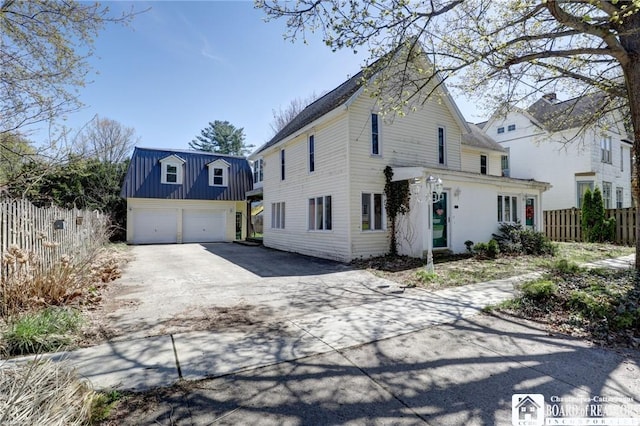 view of front facade with driveway and fence