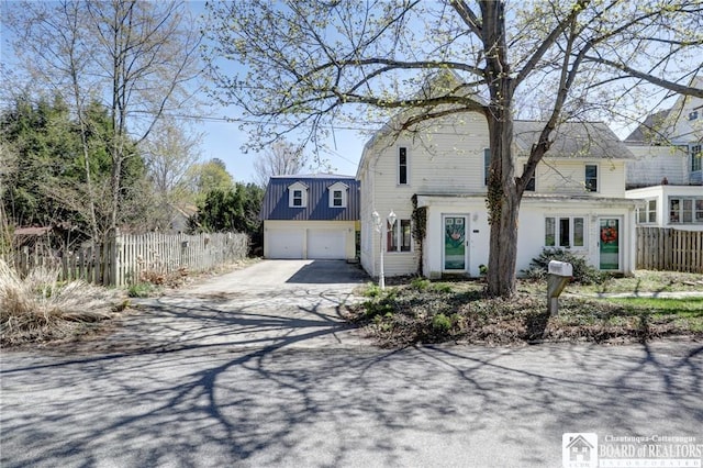 dutch colonial with fence, a gambrel roof, driveway, and a garage