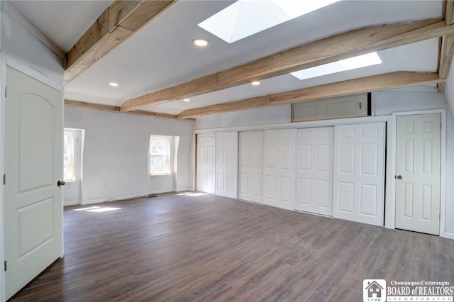 unfurnished bedroom featuring baseboards, recessed lighting, a skylight, beamed ceiling, and wood finished floors
