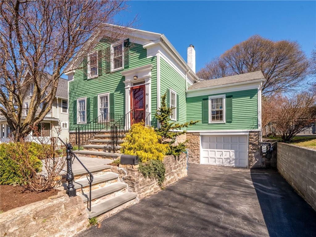 80 Winton Rd S, Rochester, NY 14610 - italianate home featuring an attached garage, driveway, a chimney, and stone siding