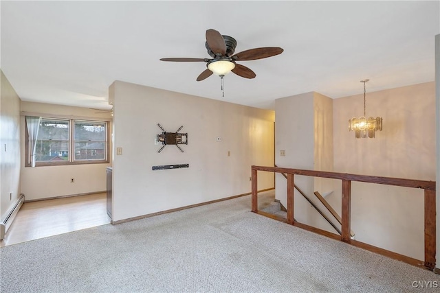 carpeted spare room featuring baseboards, baseboard heating, and ceiling fan with notable chandelier