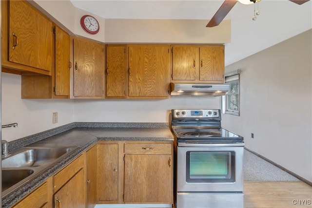 kitchen with a ceiling fan, dark countertops, range hood, stainless steel electric range, and a sink
