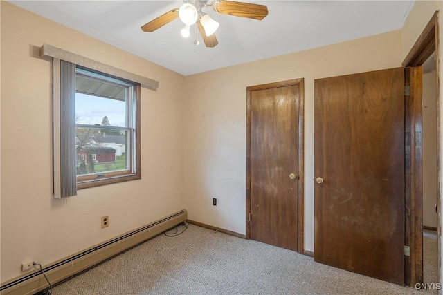 unfurnished bedroom featuring ceiling fan, carpet floors, a baseboard radiator, baseboards, and two closets