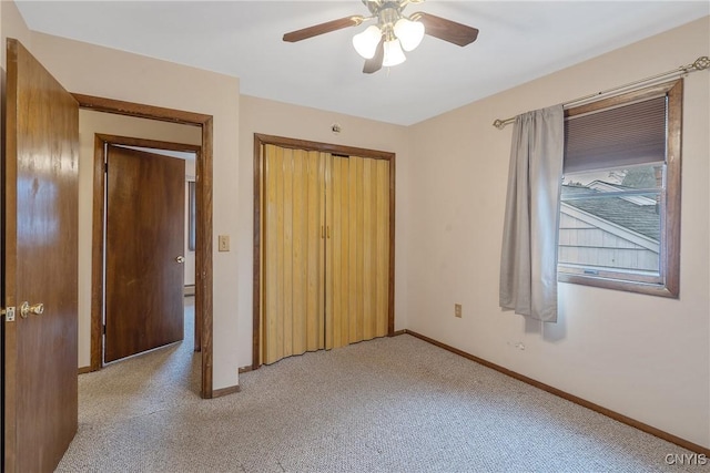 unfurnished bedroom with baseboards, a ceiling fan, a closet, and light colored carpet
