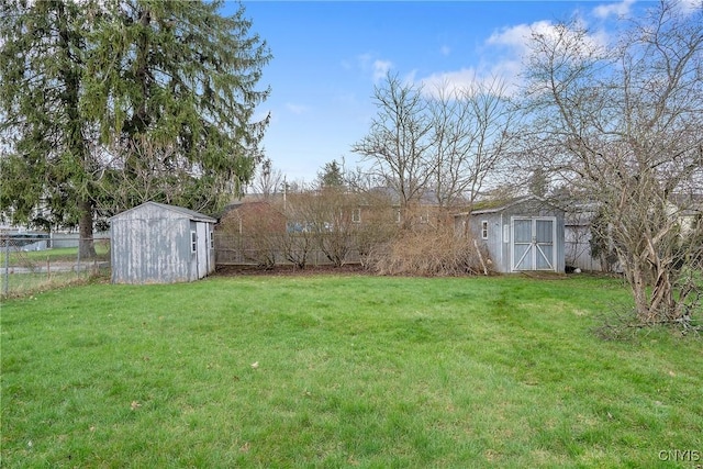 view of yard with fence, a storage unit, and an outdoor structure
