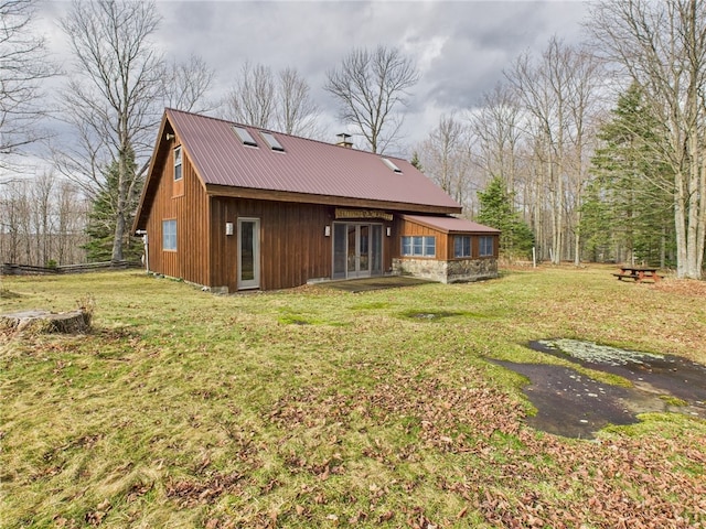 rear view of property with a yard, metal roof, and french doors