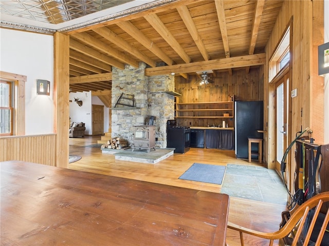 651 Dennis Hill Rd, Harrison, PA 16948 - unfurnished living room featuring a wood stove, wood walls, beamed ceiling, hardwood / wood-style floors, and wooden ceiling
