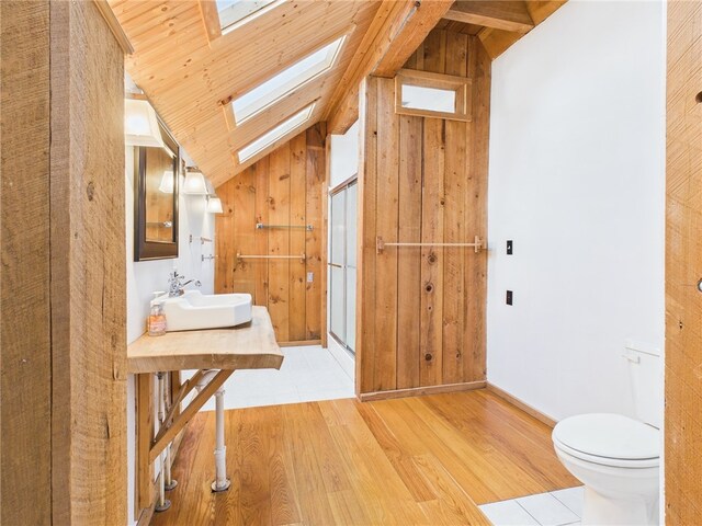 651 Dennis Hill Rd, Harrison, PA 16948 - bathroom featuring a skylight, a sink, wood finished floors, lofted ceiling, and toilet