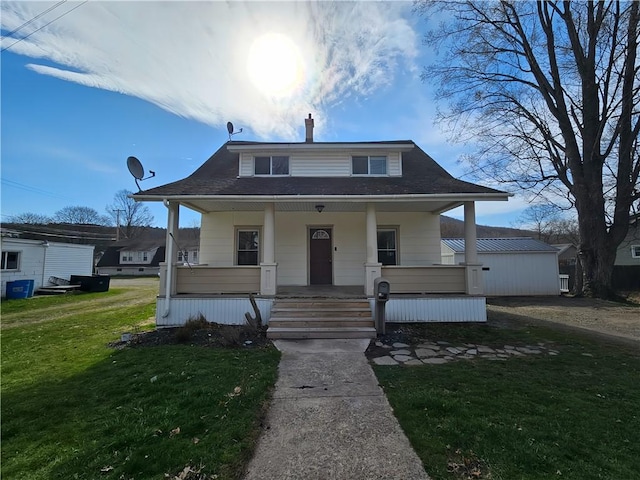bungalow featuring a porch and a front lawn