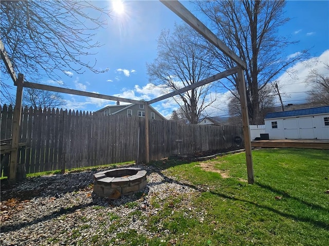 view of yard featuring fence, a fire pit, an outdoor structure, and a deck