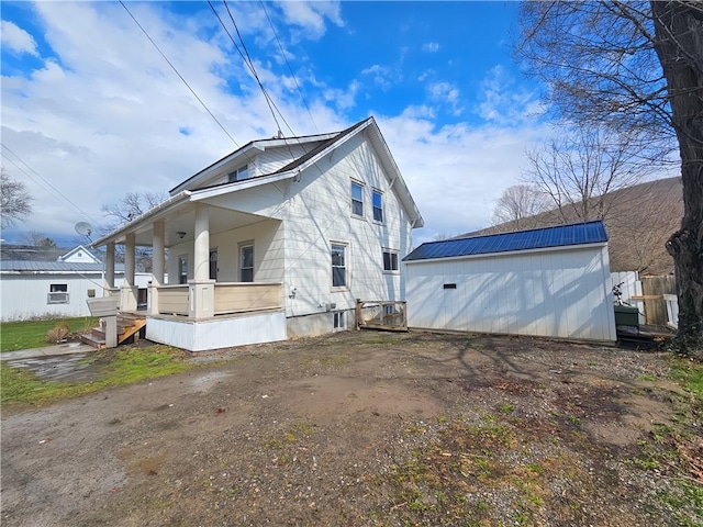 view of side of property with an outbuilding and a porch