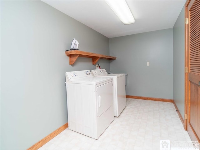 clothes washing area with light floors, baseboards, laundry area, and washing machine and dryer
