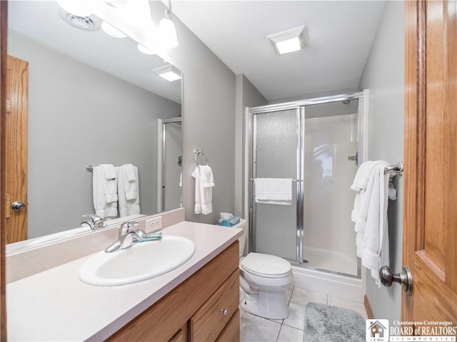 bathroom featuring vanity, toilet, tile patterned flooring, and a stall shower