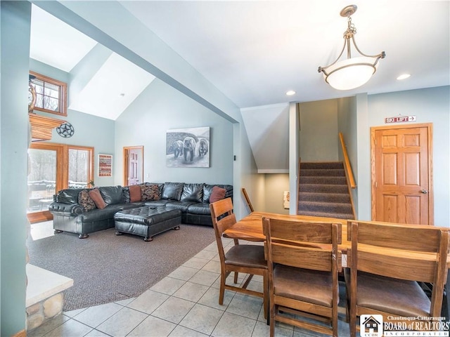 dining room featuring light carpet, plenty of natural light, stairway, and light tile patterned flooring