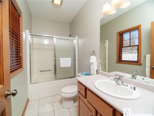 bathroom with vanity, toilet, tile patterned flooring, and bath / shower combo with glass door