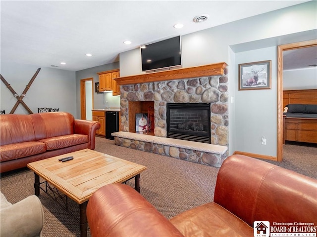 living area with light carpet, visible vents, baseboards, recessed lighting, and a fireplace