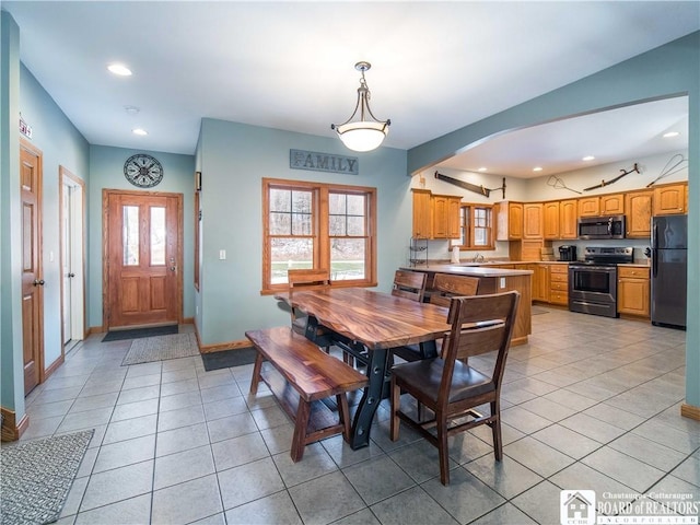 dining room with arched walkways, light tile patterned floors, baseboards, and recessed lighting