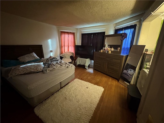 bedroom featuring light wood-style flooring and a textured ceiling