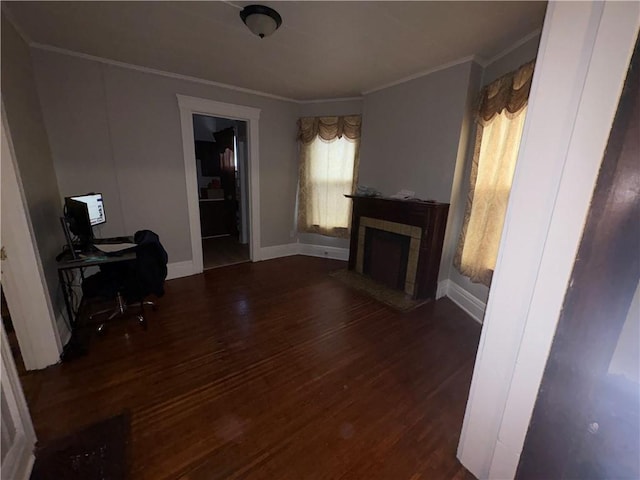 living area with baseboards, ornamental molding, wood finished floors, and a tiled fireplace